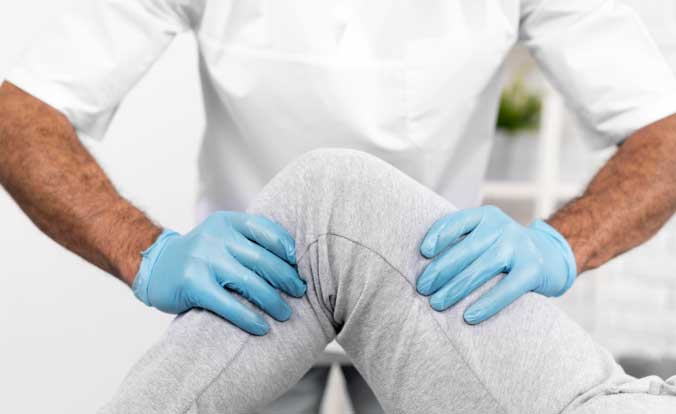 A health professional helping a patient to bend their left knee.