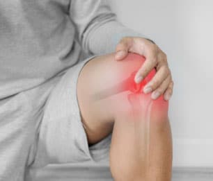 Patient holding their knee in pain.